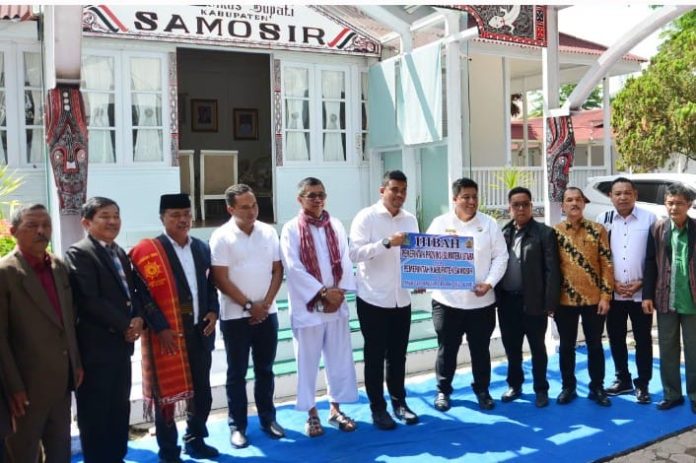 Text foto : PENYERAHAN ASET Gubernur Sumatera Utara (Sumut) Muhammad Bobby Afif Nasution menyerahkan aset Pemerintah Provinsi (Pemprov) kepada Bupati Kabupaten Samosir Vandiko Gultom berupa bangunan yang selama 21 tahun digunakan sebagai Rumah Dinas Bupati, di Pangururan, Samosir, Minggu (6/7/2025). Foto: istimewa