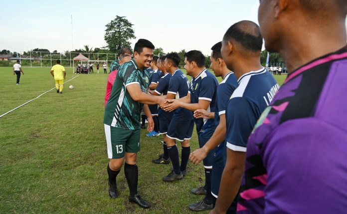 Text foto : Gubernur Sumut Bobby Nasution selaku Ketua Tim Pemprov Sumut dan Brigjen TNI (Mar) Jasiman Purba selaku Ketua Tim Lantamal I Belawan, saling bertukar cendera mata, sebelum laga persahabatan yang berlangsung di Lapangan Sepak Bola Komplek Perumahan Dinas TNI Angkatan Laut (AL) Barakuda, Tanjung Mulia Medan, Rabu (16/7/2025). (Foto : Ist)