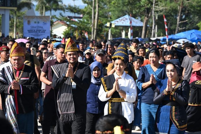Text foto : Gubernur Sumatera Utara (Sumut) Muhammad Bobby Afif Nasution didampingi Ketua TP PKK Sumut Kahiyang Ayu beserta sejumlah OPD Pemprov Sumut menghadiri acara peringatan Hari Jadi ke-22 Kabupaten Pakpak Bharat, yang berlangsung di Lapangan Alun-alun Kecamatan Salak, Senin (28/7/2025). (Foto : Ist)