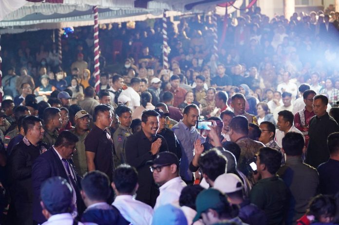Text foto : GUBSU HADIRI ULTAH HUMBAHAS KE-22 Gubernur Sumatera Utara (Sumut) Muhammad Bobby Afif Nasution didampingi Ketua TP PKK Sumut Kahiyang Ayu beserta sejumlah OPD Pemprov Sumut menghadiri acara peringatan Hari Jadi ke-22 Kabupaten Humbanghasundutan, yang berlangsung di Lapangan Kompleks Perkantoran Bukit Inspirasi, Jalan Mayor Saut T. Purba, Doloksanggul, Senin (28/7/2025) malam. (Foto : Ist)