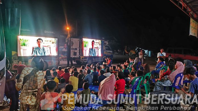 Text foto : Para relawan bersama warga korban banjir dan longsor dari Desa Garoga, Hutagodang dan Ngandol, beramai ramai menonton film 