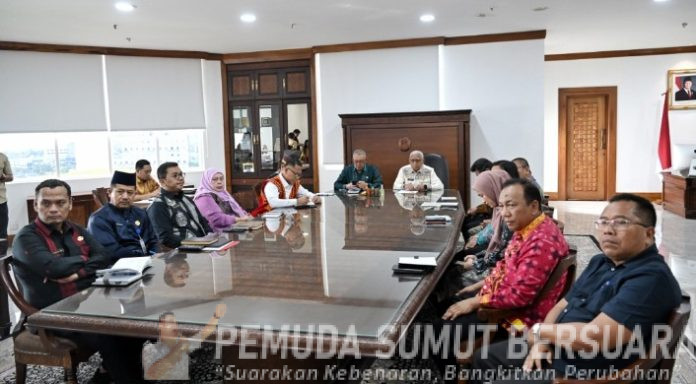Teks Foto :  Wakil Gubernur Sumatera Utara (Sumut) Surya didampingi beberapa Pimpinan OPD Sumut mengikuti zoom meeting terkait tentang Entry Meeting Serentak pemeriksaan interim Laporan Keuangan Pemerintah Daerah (LKPD) se- Kabupaten/ Kota Provinsi Sumatera Utara Tahun 2025 di ruang kerja Wakil Gubernur Kantor Gubernur Sumut Jalan Diponegoro Nomor 30 Medan, Kamis (19/2/2026).(Foto : Ist) 